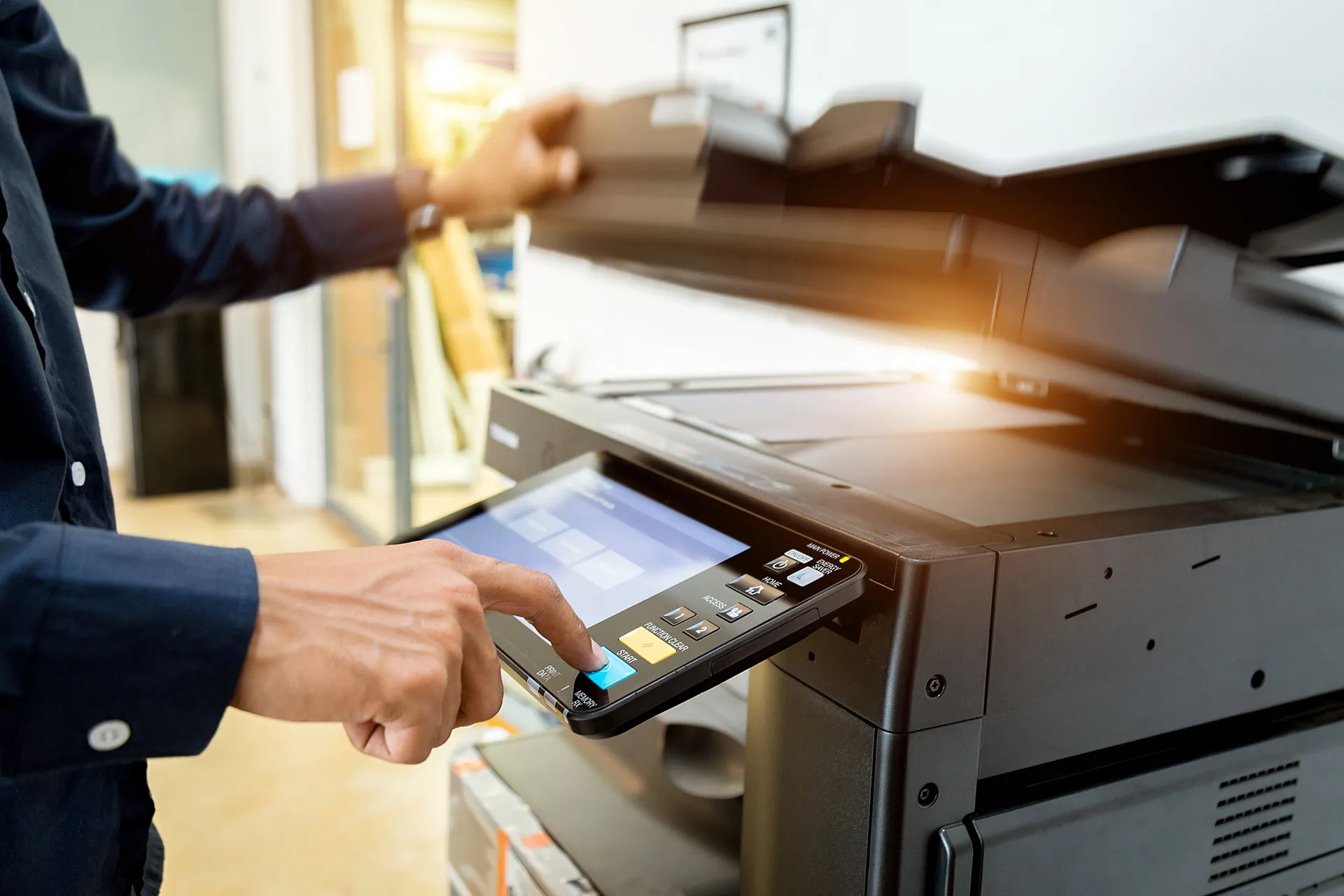 Mitarbeiter bedient das Touch-Display eines Multifunktionsdruckers im Büro
