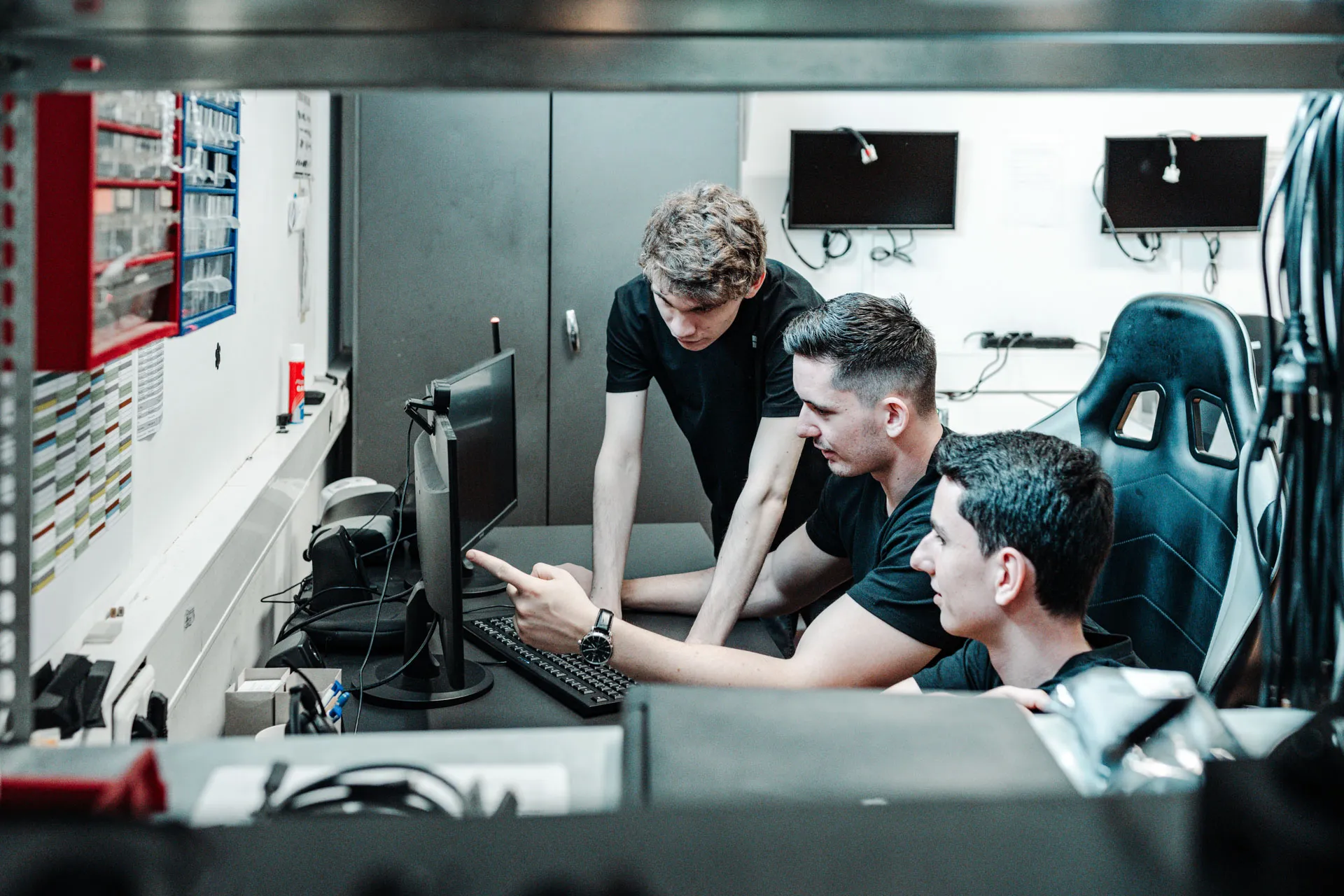 Three colleagues discussing a solution together on a screen
